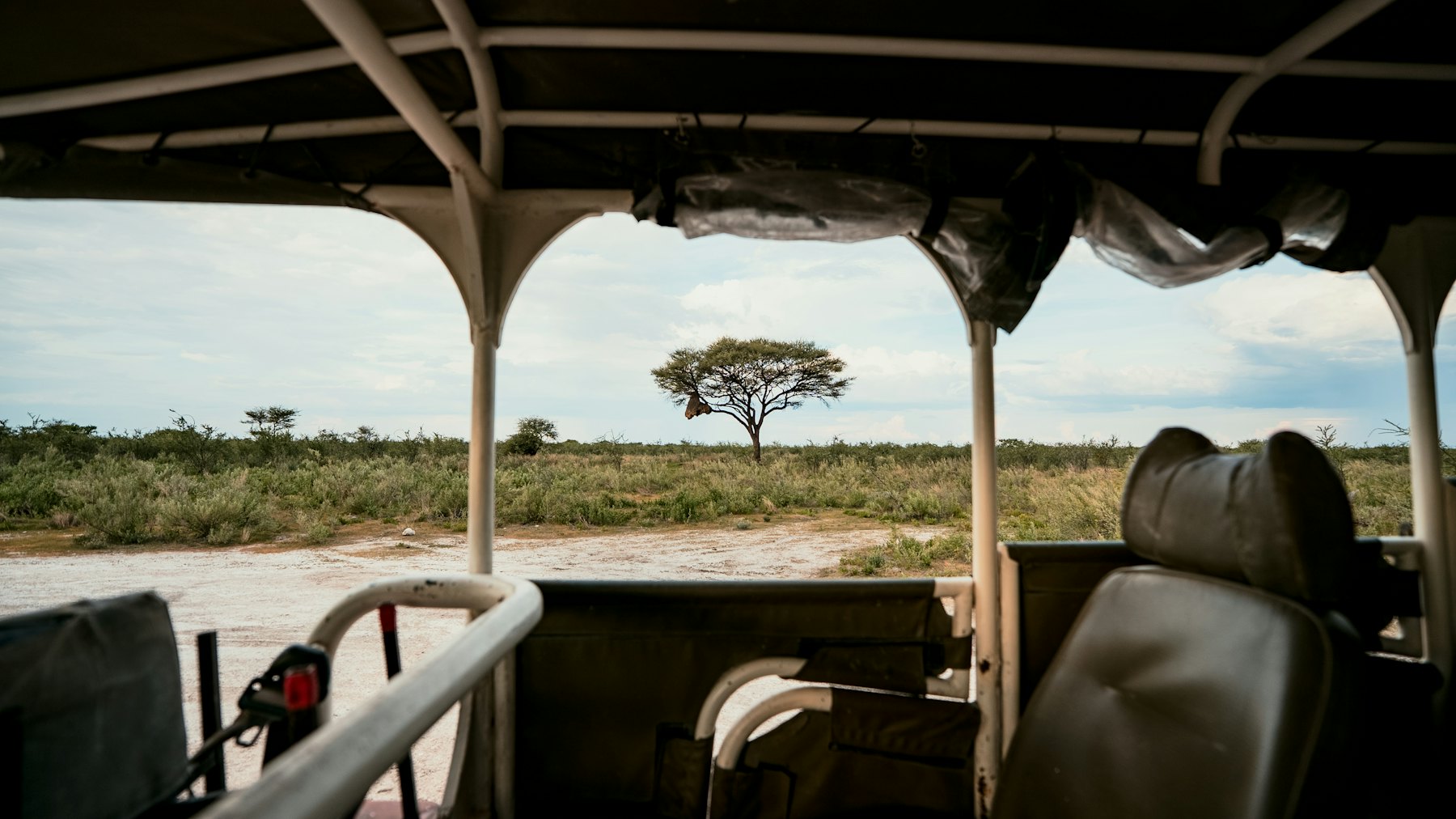Safari voertuig in een open landschap bij zonsondergang